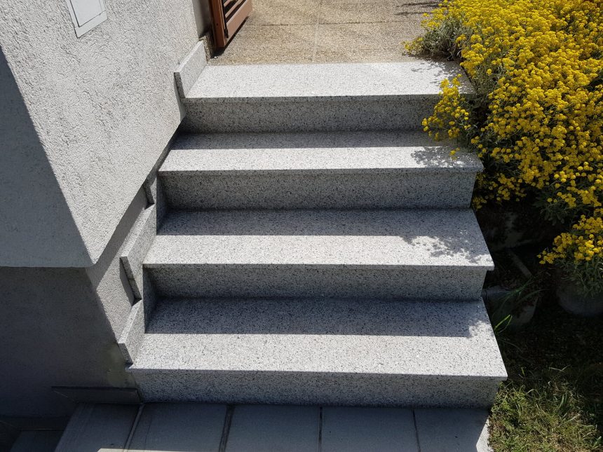 Außentreppe aus Granit mit bepflanzter Böschung